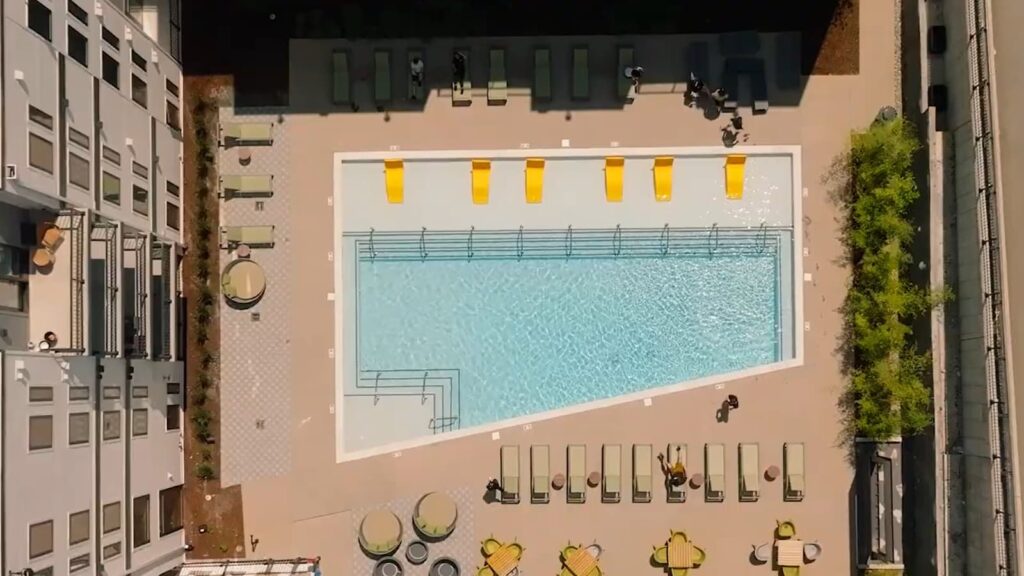 An aerial view of a rooftop swimming pool with loungers