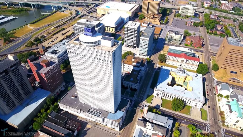 A top-down shot of a cityscape featuring a tall building and a river