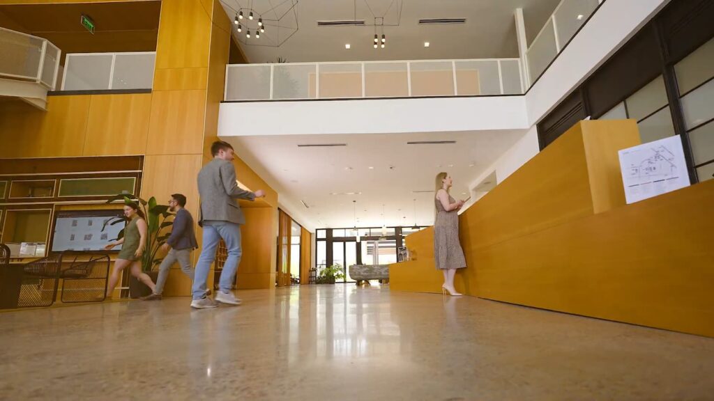 People walking through a modern hotel lobby with wooden accents