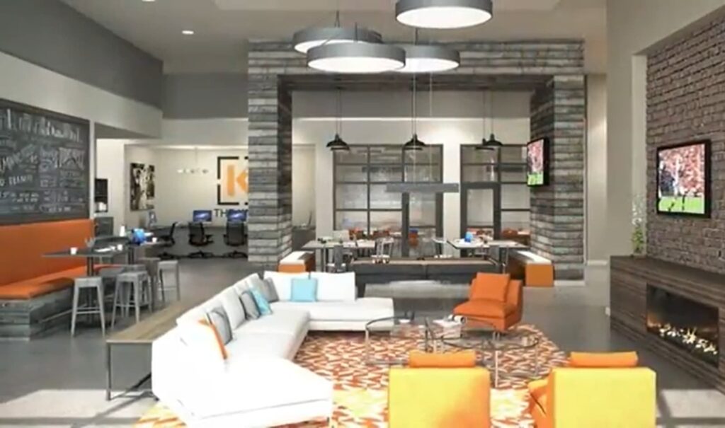 A modern open-plan lounge area with vibrant orange accents