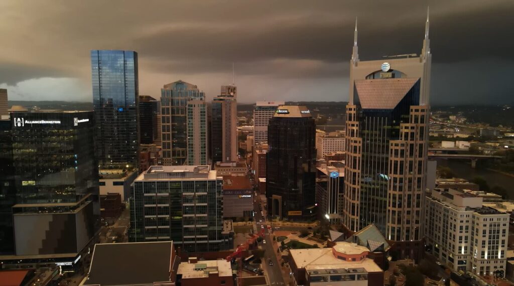 City skyline under stormy skies, with distinctive buildings