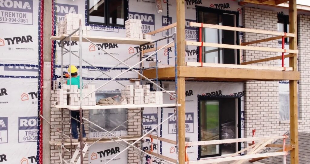A man lays bricks for the wall of a house